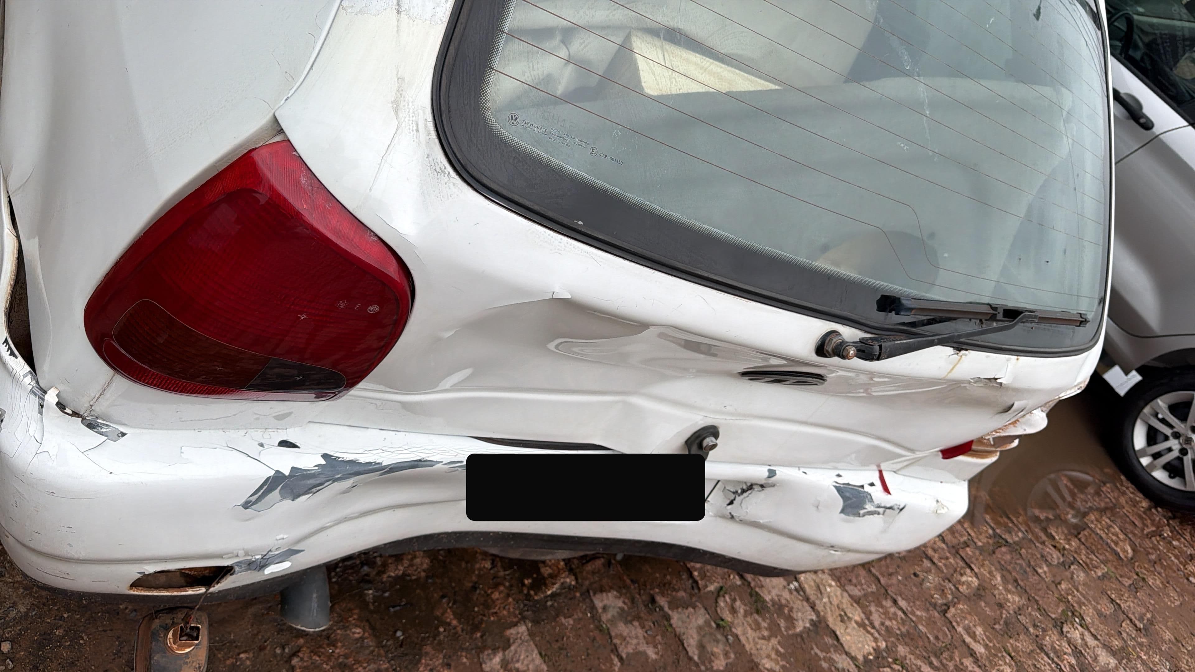 Volkswagen Gol branco com avarias antes do reparo