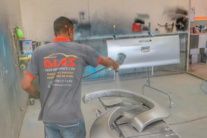Profissional da Funilaria Dias realizando serviço de pintura automotiva